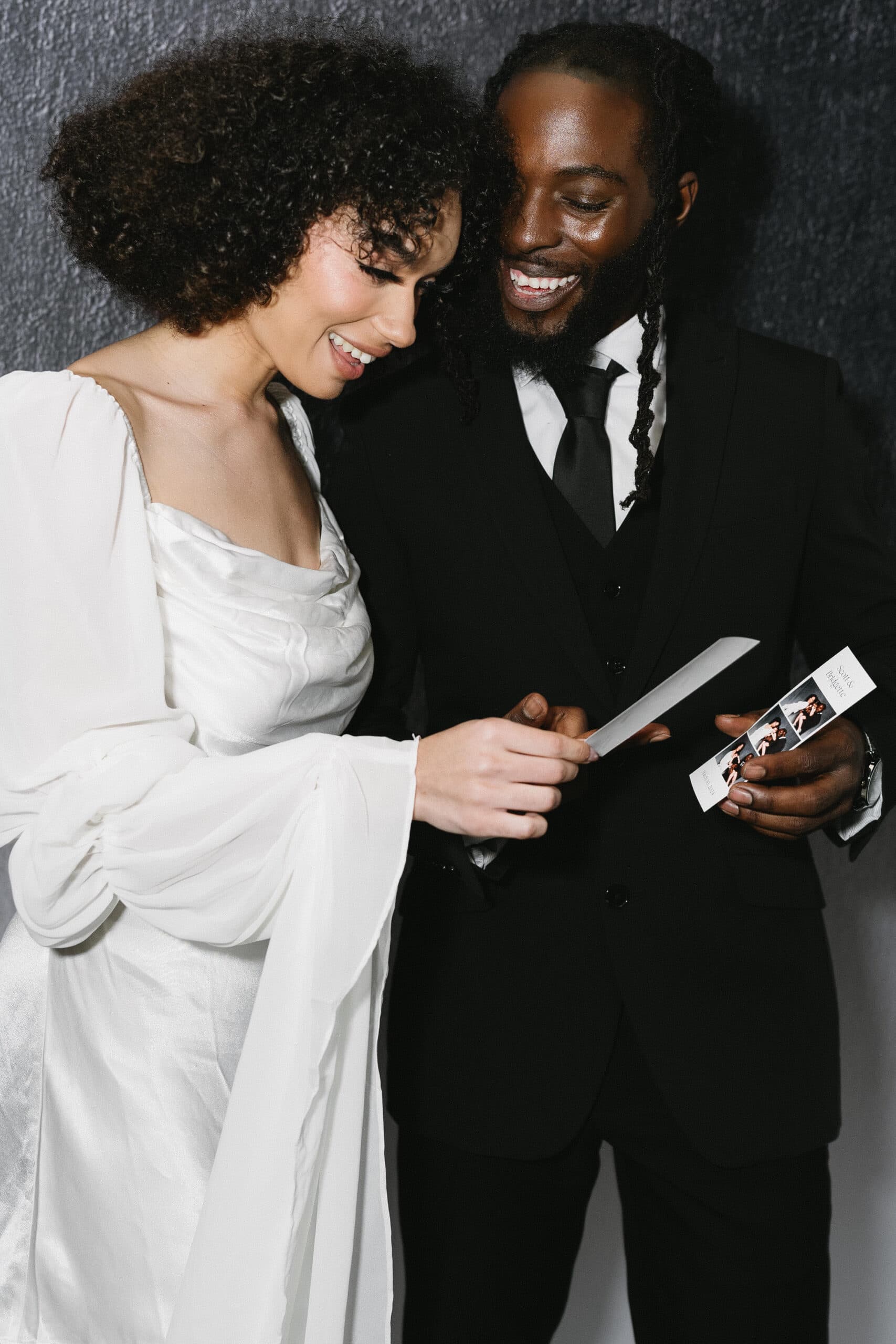 Couple admiring their photo booth strip together
